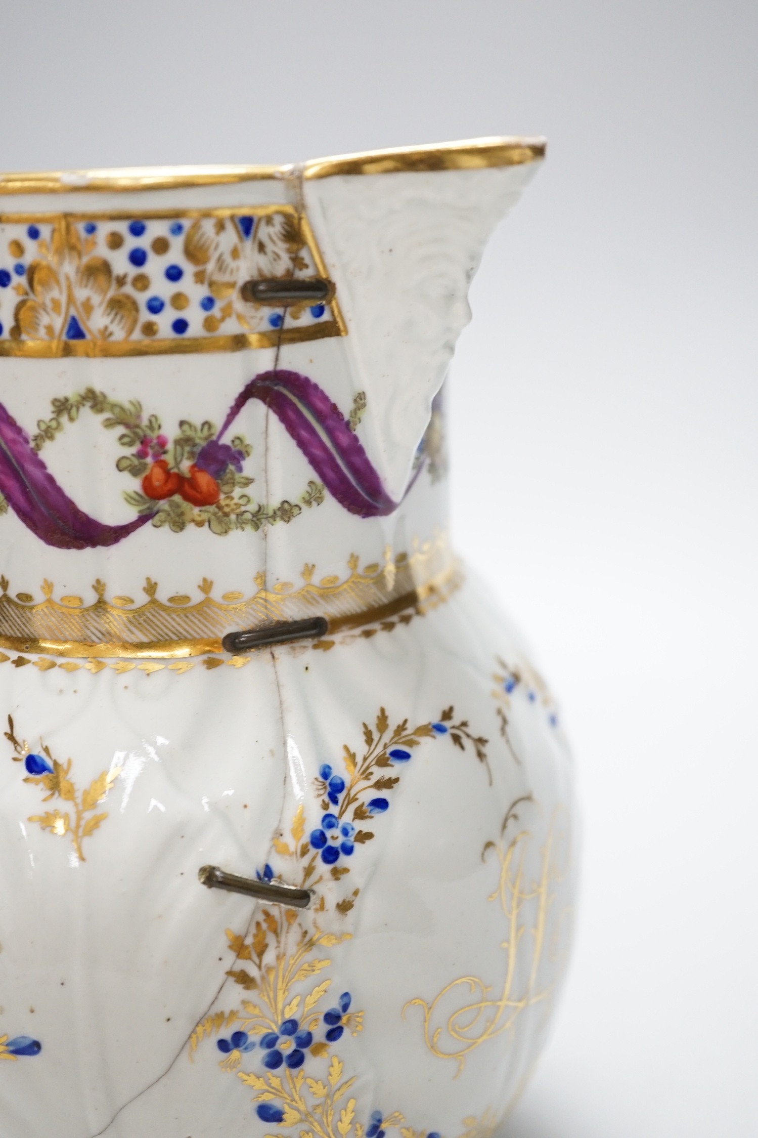 An 18th century Caughley very rare polychrome mask jug, elaboratley painted and gilded with two initials in a dry blue and gilt wreath, Gittins Col., Pictured Caughley Bicentenary Exhibition 1999, with labels, 19cms high